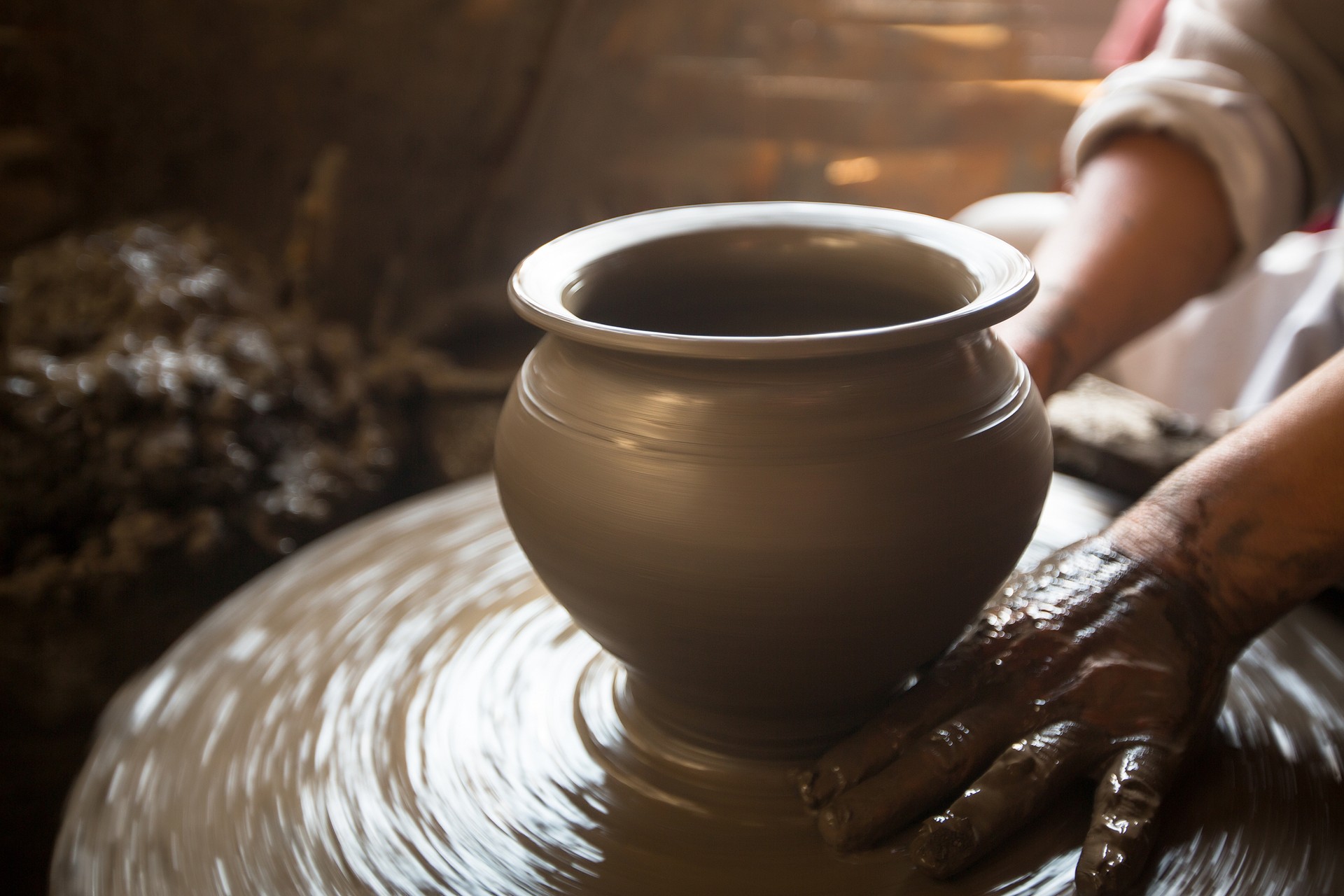 Close-up of hands working clay on potter's wheel